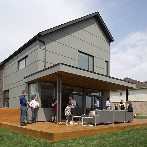 Family standing on patio in front of Active House in Canada